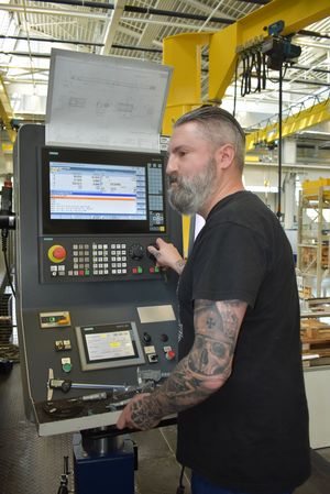 A man operating a CNC operating panel