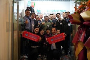 A collective of people in an entrance hall holding a red banner