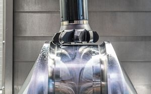 Close up view of a section of a crankshaft. The toolbit is at a slight angle, machining the section of the crankshaft