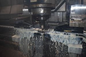 An injection molding screw being milled and cooling lubricant being sprayed on the part