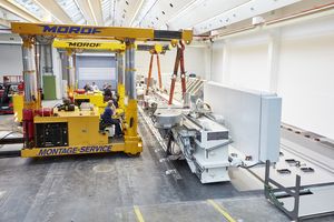 Two boom trucks position the machining center